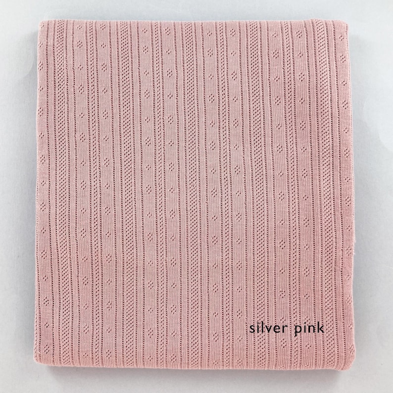 Peut inclure: Un tissu tricot&eacute; rose argent&eacute; avec un motif textur&eacute;. Le tissu est doux et a un l&eacute;ger &eacute;clat.
