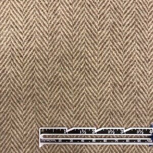Puede incluir: Primer plano de una tela de espiga marr&oacute;n y beige con una regla que mide 10 cm.