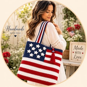 Pode incluir: Uma bolsa tote retangular de crochê com um padrão de bandeira americana em vermelho, branco e azul com estrelas brancas em um campo azul. A bolsa inclui uma borla vermelha e alças listradas. O texto na bolsa diz Handmade with love.