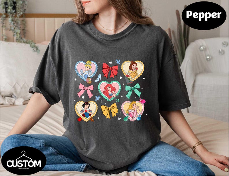 a woman sitting on a bed wearing a t - shirt