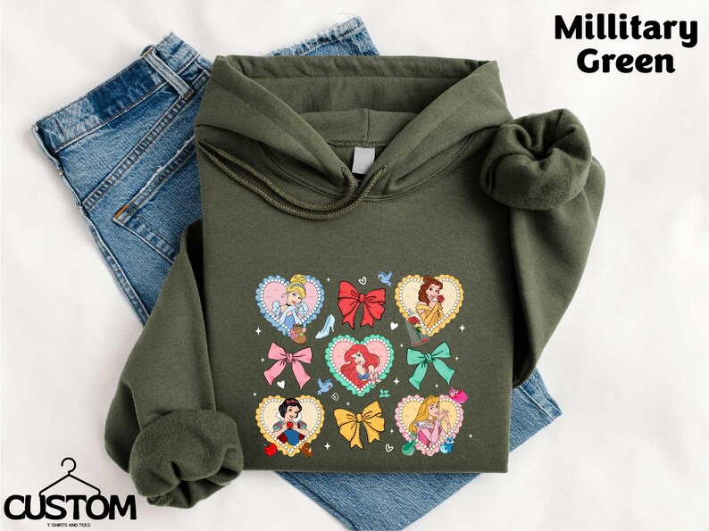 a green hoodie with a picture of princesses on it