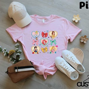 a pink shirt with a bunch of cartoon characters on it