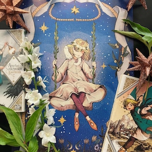 May include: An illustrated print featuring a girl on a swing against a starry blue background. The girl wears a floral crown and light-colored dress. Decorative stars and floral accents surround the print, with additional illustrations and text visible.
