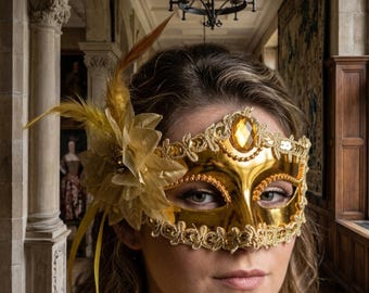 Máscara de carnaval dorada con gema de ámbar, flor de pluma, elegante antifaz veneciano para bailes de graduación, bodas, fiestas y eventos de disfraces renacentistas.