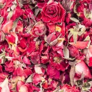 Könnte beinhalten: Nahaufnahme von getrockneten roten Rosenblütenblättern und -knospen. Das Bild zeigt eine Mischung aus ganzen und fragmentierten Blütenblättern, mit einigen grünen Kelchblättern. Die Farbpalette wird von tiefen Rottönen und Brauntönen dominiert.