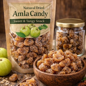 May include: Image of Amla Candy, a sweet and tangy snack. The image shows a clear bag and a glass jar filled with the candy, a wooden bowl, and a small wooden spoon. The packaging reads "Natural Dried Amla Candy".