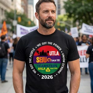 May include: Black t-shirt with a circular graphic featuring the text "WE GOT THE POWER" and "UNION STRONG." The graphic includes the text "UTLA," "SEIU Local 99," "TEAMSTERS AALA Local 2010," and the year "2026." The shirt is worn by a person.