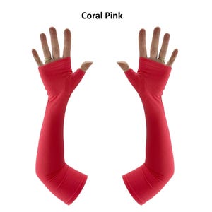May include: A pair of coral pink fingerless arm sleeves that extend from the knuckles to the forearm. The fabric is a solid, smooth material with a thumb hole opening. The text Coral Pink is displayed at the top centre of the image.