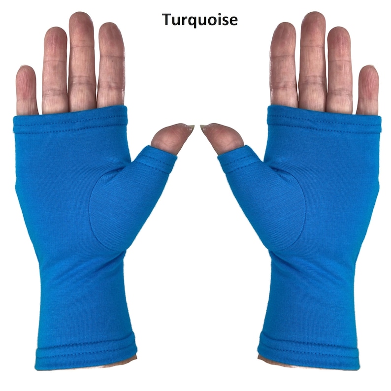 May include: A pair of fingerless gloves in a solid turquoise color. The gloves feature a thumb hole and extend from the knuckles down to the wrist, with stitched hems at the top and bottom edges. The word Turquoise is printed above the gloves.