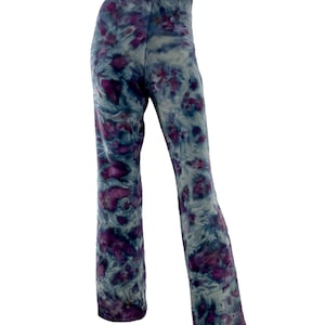 May include: Tie-dye pants in shades of blue, gray, and purple. The pants have a flared leg and an elastic waistband. The tie-dye pattern features a mix of swirling and blotchy designs, creating a unique and artistic look.