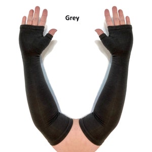 May include: A pair of grey fingerless arm sleeves that extend from the knuckles to the upper forearm. The sleeves feature a thumb hole opening and a finished hem at both the top and bottom edges. The word Grey is printed above the sleeves.
