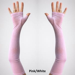 May include: A pair of long, fingerless gloves in a light pink hue, extending from the knuckles up to the mid-forearm. The fabric appears smooth and lightweight, covering the palm and wrist while leaving the fingers exposed. Text reads Pink/White.