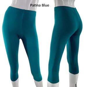Puede incluir: Leggings piratas Patina Blue con cintura el&aacute;stica de talle alto y corte ajustado. La prenda se muestra de frente y de espaldas sobre un maniqu&iacute;, exhibiendo un color azul verdoso profundo y s&oacute;lido en toda la superficie de la tela.
