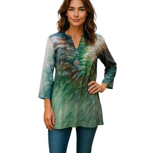 May include: A green and blue tie-dye tunic top with a v-neck and 3/4 sleeves. The top features a silver pendant necklace.