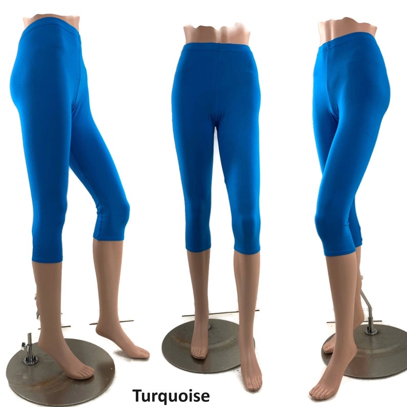 Puede incluir: Leggings capri de color turquesa brillante mostrados desde tres &aacute;ngulos diferentes en un maniqu&iacute;. Los leggings presentan un dise&ntilde;o de cintura alta con una tela lisa de color s&oacute;lido que llega justo debajo de la rodilla. El texto Turquoise es visible.