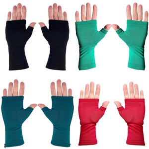May include: Four pairs of fingerless compression gloves in black, bright green, teal, and red. Each pair features a thumb hole and covers the palm and wrist area, leaving the fingers exposed. The fabric appears smooth and solid in color.