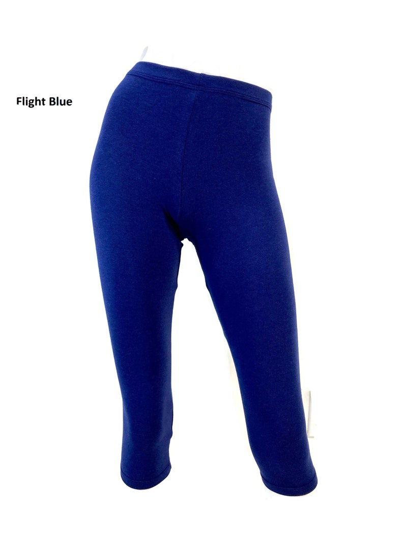 Puede incluir: Unos leggings de color azul oscuro s&oacute;lido con cintura alta y longitud recortada. El texto Flight Blue est&aacute; impreso en el lado izquierdo de la imagen. La prenda se muestra sobre un maniqu&iacute; contra un fondo blanco liso.