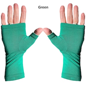 May include: A pair of fingerless gloves in a solid green color. The gloves feature a thumb hole and extend from the knuckles down to the wrist, with a simple hemmed edge at both the top and bottom openings. The word Green is printed above.