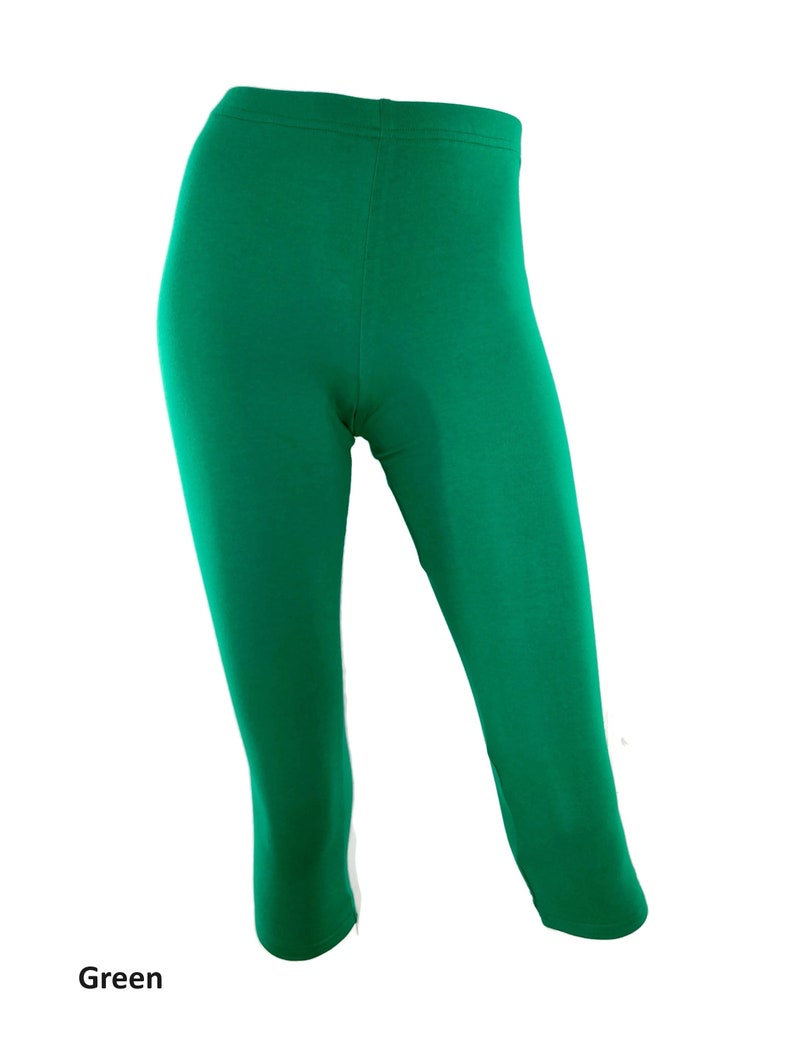 Puede incluir: Leggings cortos de color verde s&oacute;lido con una cintura el&aacute;stica alta y un corte ajustado que llega hasta la mitad de la pantorrilla. La prenda est&aacute; confeccionada en un tejido liso y opaco, e incluye la palabra Green impresa en la esquina inferior izquierda.