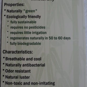 May include: A rectangular off-white product tag with dark green text detailing bamboo properties and characteristics. The text lists features including naturally green, ecologically friendly, breathable, cool, antibacterial, odor resistant, and machine washable.