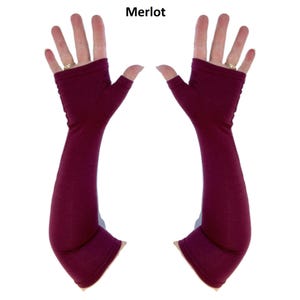 May include: A pair of fingerless arm warmers in a deep merlot colour. These long, solid-coloured sleeves extend from the knuckles to the forearm, featuring an opening for the thumb and a smooth, fitted fabric construction with the text Merlot above.