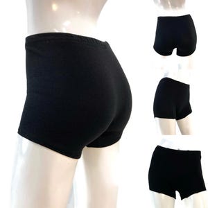 May include: Solid black boxer briefs featuring a high-waisted design with a wide, elasticated waistband. These form-fitting undergarments provide full coverage and are constructed from a smooth, opaque fabric, shown from multiple angles.