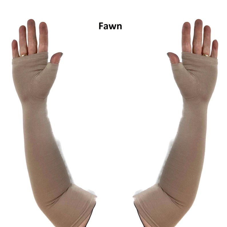 May include: A pair of fawn-coloured, long, fingerless arm sleeves made of a smooth, solid-coloured fabric. The sleeves extend from the knuckles to above the elbow, featuring a dedicated opening for the thumb and a hemmed edge at the top and bottom.
