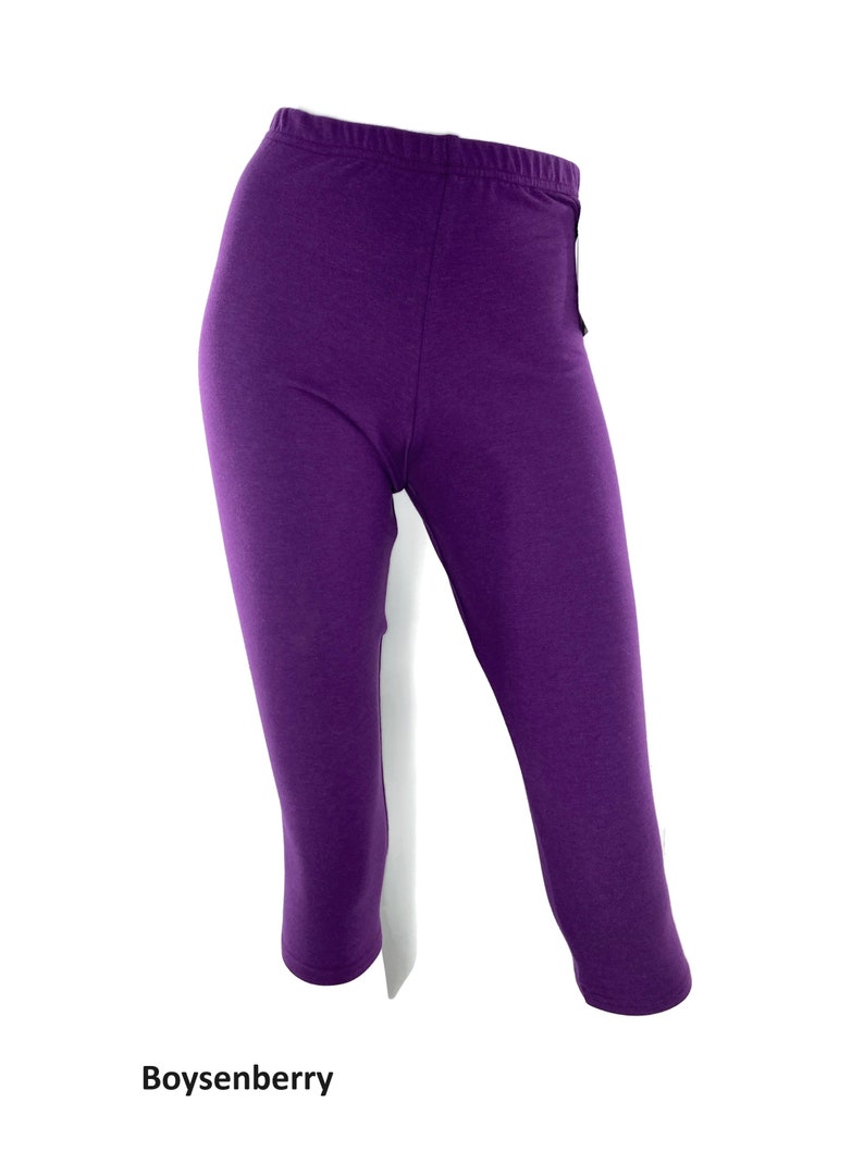 Puede incluir: Leggings capri de color morado s&oacute;lido con cintura el&aacute;stica y silueta ajustada. La tela tiene una textura suave y consistente en toda la prenda. El texto Boysenberry est&aacute; impreso en negro en la parte inferior de la imagen.