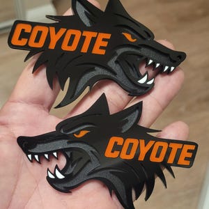 May include: A set of three ceramic mugs with a speckled, matte finish. The mugs are in shades of cream, light gray, and dark gray. Each mug has a simple, modern design and a rounded handle.