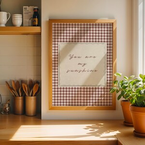 May include: A white ceramic mug with a black handle and the text "But First, Coffee" in a bold, black font. The mug is set against a blurred background, suggesting a cozy setting. The mug appears to be approximately 4 inches tall.