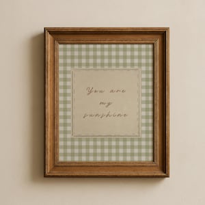 May include: A framed print with a brown wooden frame. The print features a light green and white gingham pattern background. A beige square in the center has the words "You are my sunshine" in a handwritten style font.
