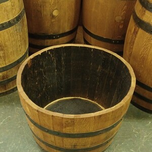 Pu&ograve; includere: Un vaso da fiori in legno a forma di barile con fasce di metallo nero. Il barile &egrave; in legno naturale e ha una tinta marrone scuro. Il vaso &egrave; vuoto e pronto per essere riempito di piante.