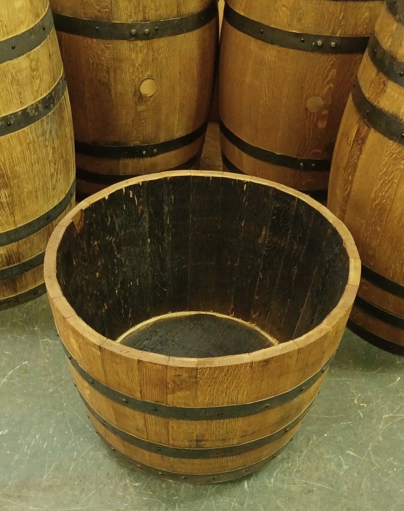 Pu&ograve; includere: Un vaso da fiori in legno a forma di barile con fasce di metallo nero. Il barile &egrave; in legno naturale e ha una tinta marrone scuro. Il vaso &egrave; vuoto e pronto per essere riempito di piante.