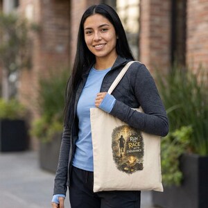 Può includere: Borsa tote beige con la scritta "Run the Race with Endurance" e una grafica di un corridore. La borsa ha cinghie color crema ed è tenuta da una persona che indossa una camicia blu e una giacca grigia. Lo sfondo è una scena sfocata all'aperto.