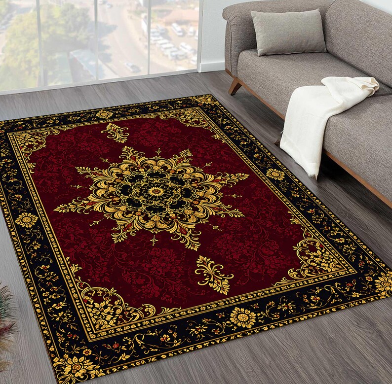 Puede incluir: Una alfombra rectangular que presenta un campo de color rojo burdeos intenso con un gran medall&oacute;n central intrincado en oro y negro. La alfombra est&aacute; enmarcada por un borde negro ancho adornado con motivos florales dorados repetidos.