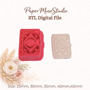 May include: A red plastic book-shaped cookie cutter and a light-colored clay impression of the same design featuring an eye motif. The text Paper Muse Studio STL Digital File is visible at the top, with sizes 25mm, 30mm, 35mm, 40mm, 45mm listed.