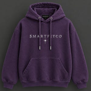 May include: A deep purple long-sleeve hooded sweatshirt featuring a front kangaroo pocket and matching drawstring cords. The text SMARTFITCO is printed in white across the chest, accompanied by a small four-pointed star graphic below the text.