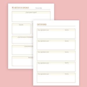 May include: Two white paper pages with Spanish text. One page is titled "MIS OBJETIVOS DE CONFIANZA" and the other is titled "GRATITUD DIARIA". The pages have sections for writing goals, challenges, resources, and gratitude. The background is a light pink.