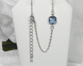 Peut inclure: Un collier argenté avec un pendentif carré en pierre bleue. Le collier a une chaîne réglable. La pierre est sertie dans un cadre argenté. Le collier est présenté sur un présentoir blanc.