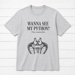 Può includere: Una t-shirt a maniche corte grigio chiaro con il testo nero "WANNA SEE MY PYTHON? Flip responsibly." sopra un'illustrazione grafica in bianco e nero di un serpente cobra dei cartoni animati con occhi grandi e lingua visibile.