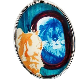 May include: A silver charm with a round, oval-shaped image of two dogs. The dogs are facing each other, one is orange and white, the other is blue and white. The charm has a silver clasp.