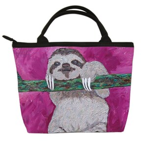 May include: A pink tote bag with a painting of a sloth hanging from a branch. The sloth has a light brown fur and white claws. The background is a bright pink color.