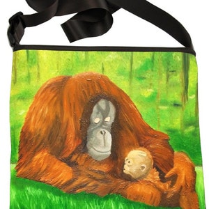 May include: A black canvas tote bag with an adjustable strap. The bag features a painting of an orangutan mother holding her baby in a green forest setting.