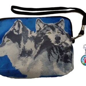 May include: A blue zippered pouch with a black strap and a silver clip. The pouch features a colorful image of two wolves on a blue background. The clip has a round charm with a red paw print on a blue globe.
