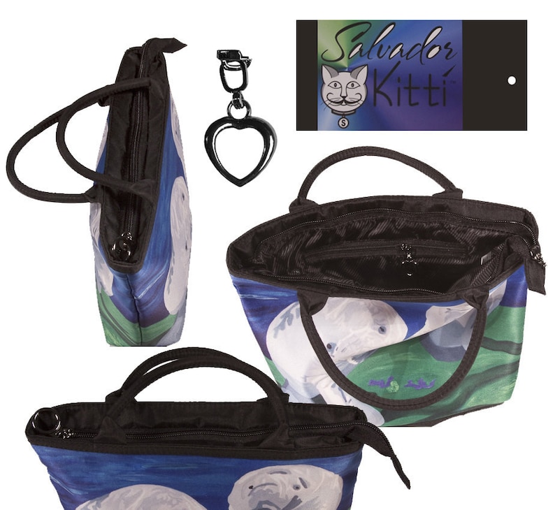 May include: A black tote bag with a zipper closure and two handles. The bag features a colorful print of two manatees swimming in blue water with green plants. The bag comes with a matching heart-shaped keychain.
