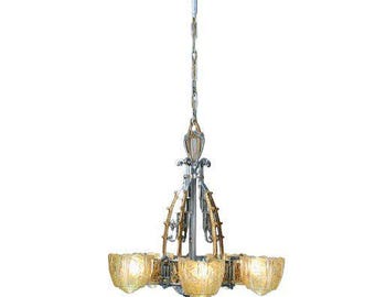 May include: A multi-light chandelier featuring a central metal frame with gold and silver-toned accents. The fixture includes several amber-colored glass shades with an embossed floral pattern, suspended by a decorative chain and canopy.