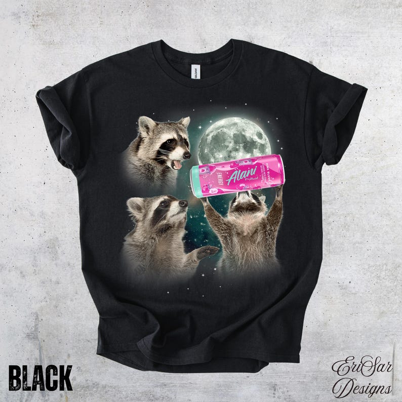 May include: Black t-shirt featuring a graphic of three raccoons with a full moon in the background. One raccoon holds a pink can of "Alani" energy drink. The word "BLACK" is printed at the bottom.