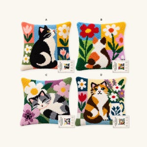 May include: Four square latch hook kit pillows featuring colorful cat and floral designs. Each pillow displays a unique feline illustration surrounded by vibrant flowers in various color blocks, labeled A, B, C, and D with small product tags.