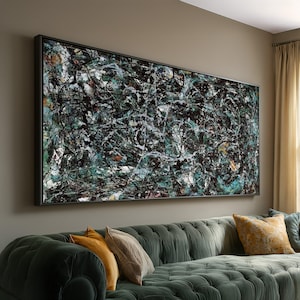 Puede incluir: Gran pintura expresionista abstracta en un marco negro. La obra presenta una compleja red de líneas y salpicaduras negras, blancas y verde azulado. La pintura cuelga sobre un sofá de terciopelo verde con cojines amarillos y beige.