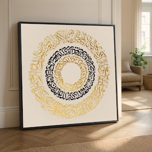 May include: A square wall art piece featuring a circular arrangement of Arabic calligraphy. The design consists of three concentric rings alternating between metallic gold and solid black script against a light cream-colored background.